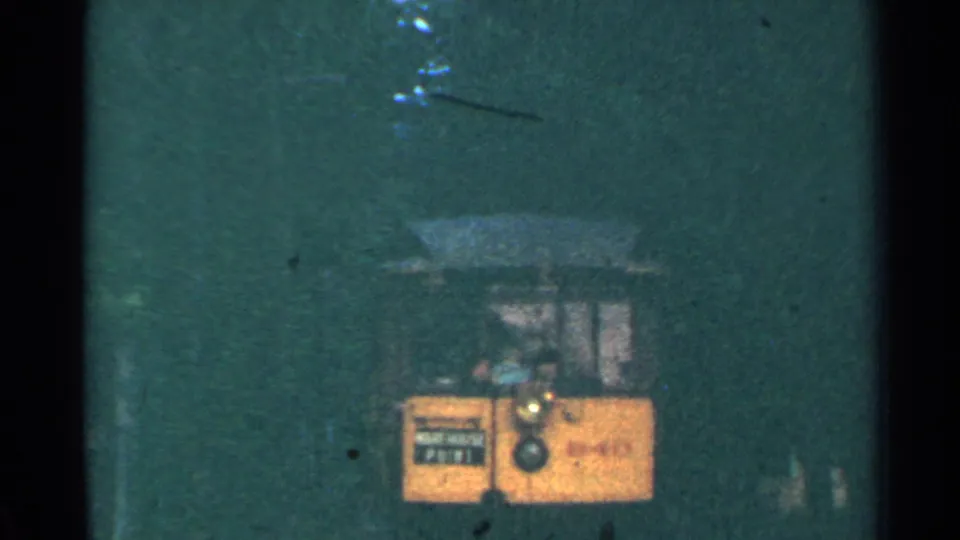 1953 Connecticut trolley receding into a shadowed tunnel, with the yellow front and route sign still partially visible.