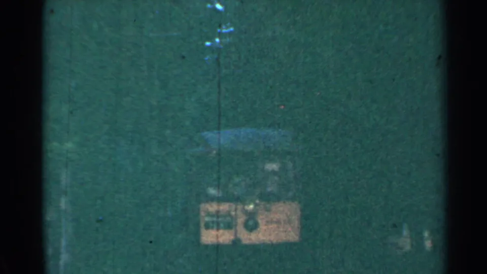 A grainy 1953 Connecticut 8mm frame shows the yellow trolley small and dim inside the tunnel.