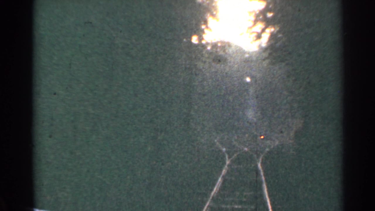 Low-angle 8mm view of Connecticut railroad tracks in 1953, with rails narrowing toward a hazy horizon.