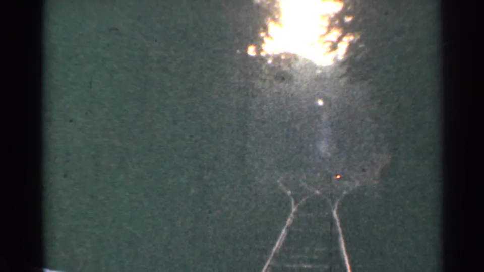 Low-angle 8mm view of Connecticut railroad tracks in 1953, with rails narrowing toward a hazy horizon.