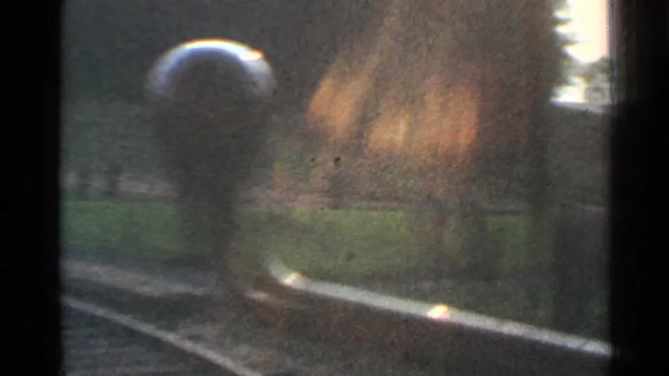 1953 Connecticut home-movie frame showing a rail vehicle close to the camera near curved tracks, with soft focus and warm film exposure.