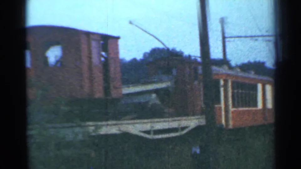1953 Connecticut frame of a trolley car on a curve near grass, a fence, a utility pole, and a small brick or masonry structure.