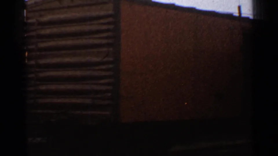 Close 1953 Connecticut rail yard view showing a dark railcar or freight car side with adjacent textured siding and heavy shadow.