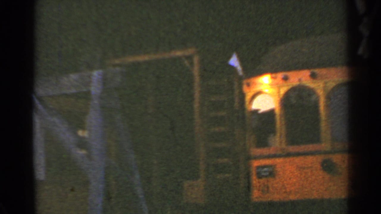 1953 Connecticut 8mm frame with the trolley cropped at the right edge, a ladder behind it, and dim station framing visible.