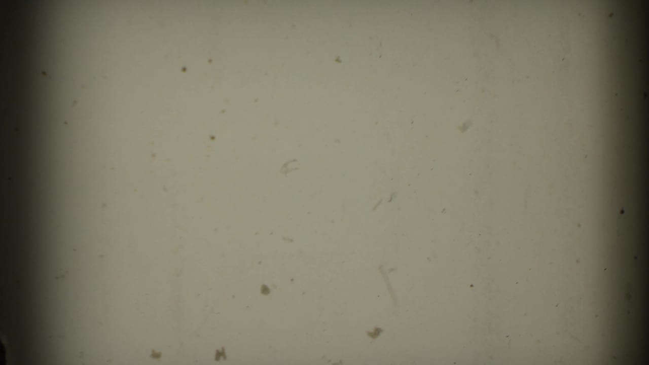A pale, mostly blank 8mm frame from the supplied Connecticut rail clip, with dust, scratches, soft exposure, and a dark central frame edge.