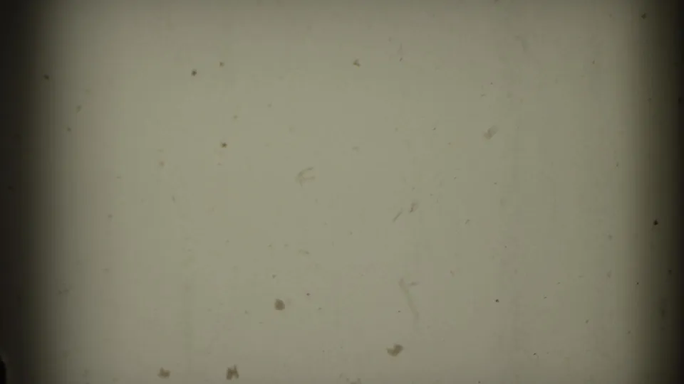 A pale, mostly blank 8mm frame from the supplied Connecticut rail clip, with dust, scratches, soft exposure, and a dark central frame edge.