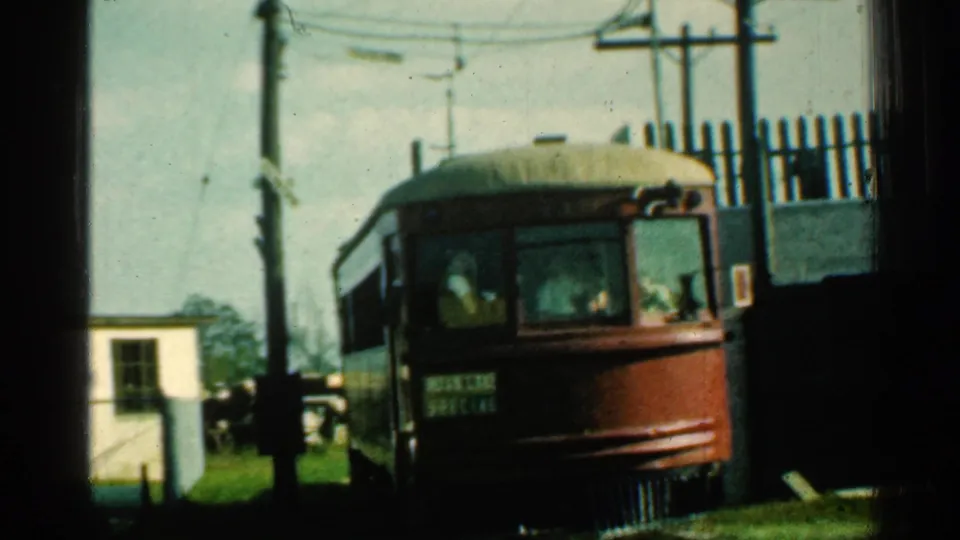 A red-and-cream trolley marked SPECIAL moves close to camera at a Connecticut crossing, with passengers faintly visible through the front windows.