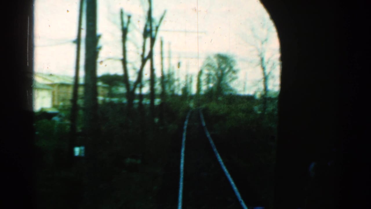 1953 Connecticut 8mm view looking forward along railroad tracks bordered by bare trees and utility poles.