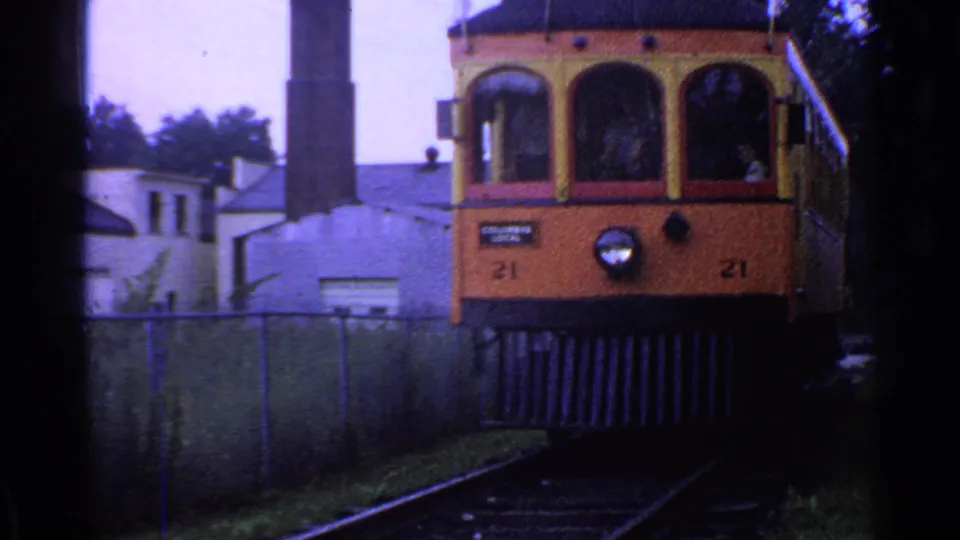Trolley car 21 nears the camera in 1953 Connecticut footage, showing its front windows, number markings, headlight, and trackside fence.