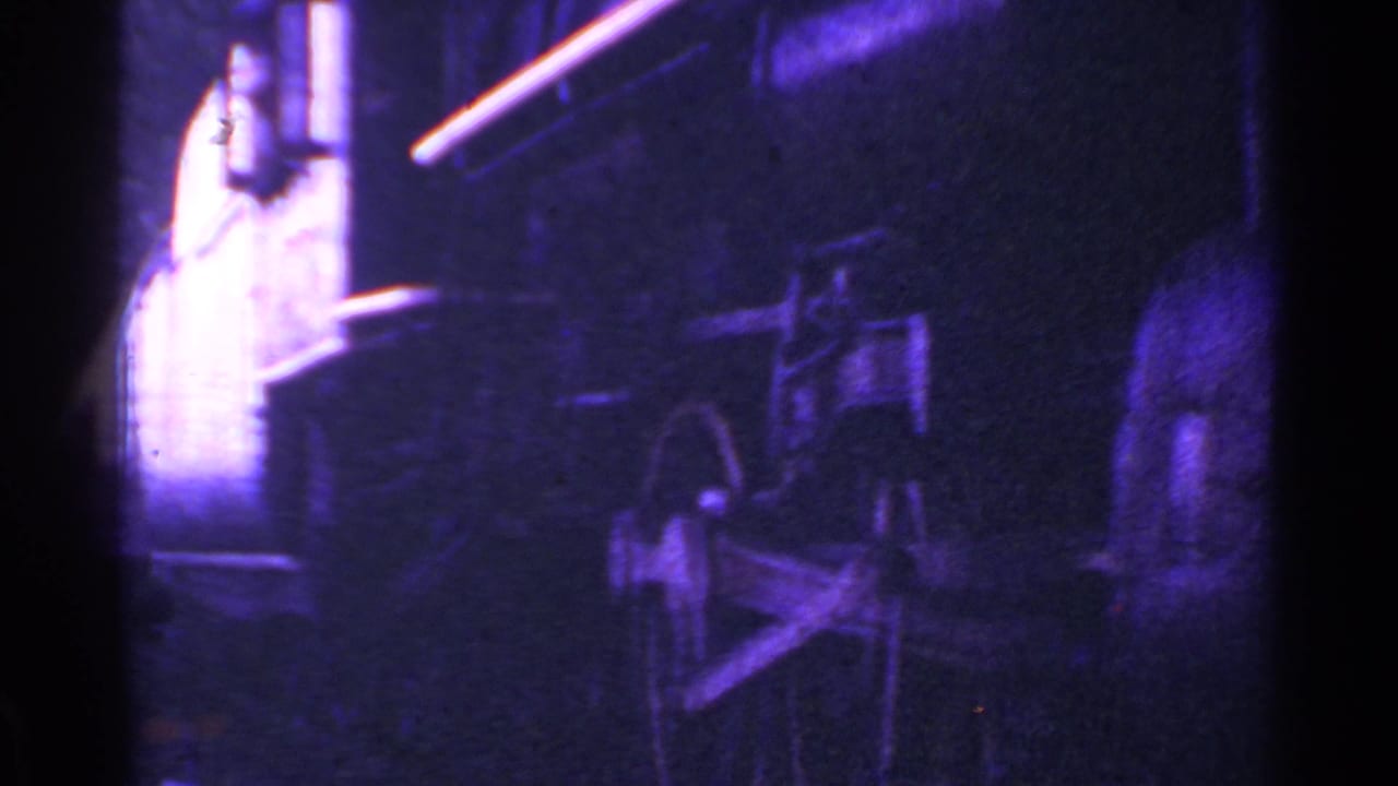 1953 Connecticut 8mm frame showing a dim, purple-blue close view of a passing train's wheel area and railcar side.