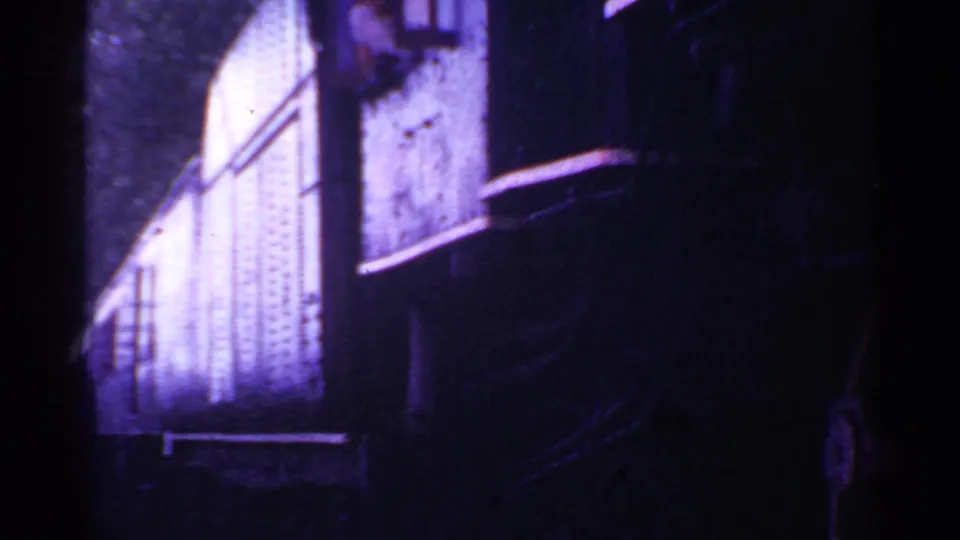 1953 Connecticut 8mm frame showing a bright metal railcar panel and dark surrounding train structure during a slow pass.
