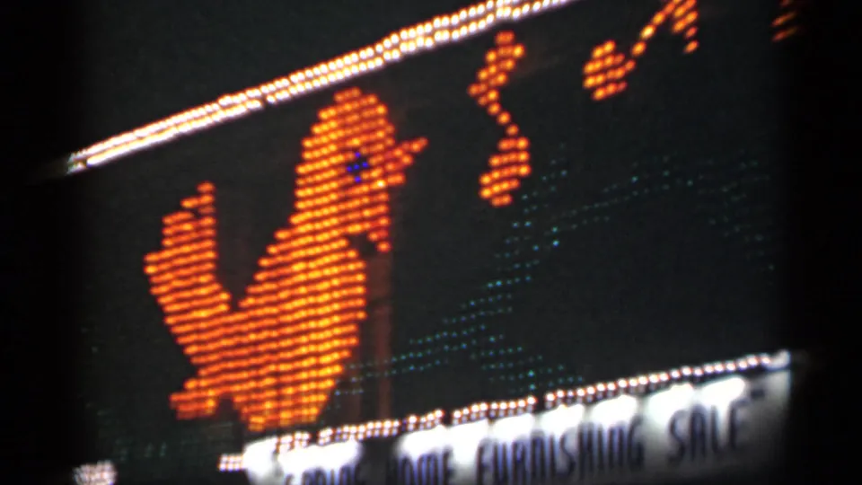 1949 New Orleans 8mm frame showing an animated-style orange bird display, music-note shapes, and bright sale signage below.
