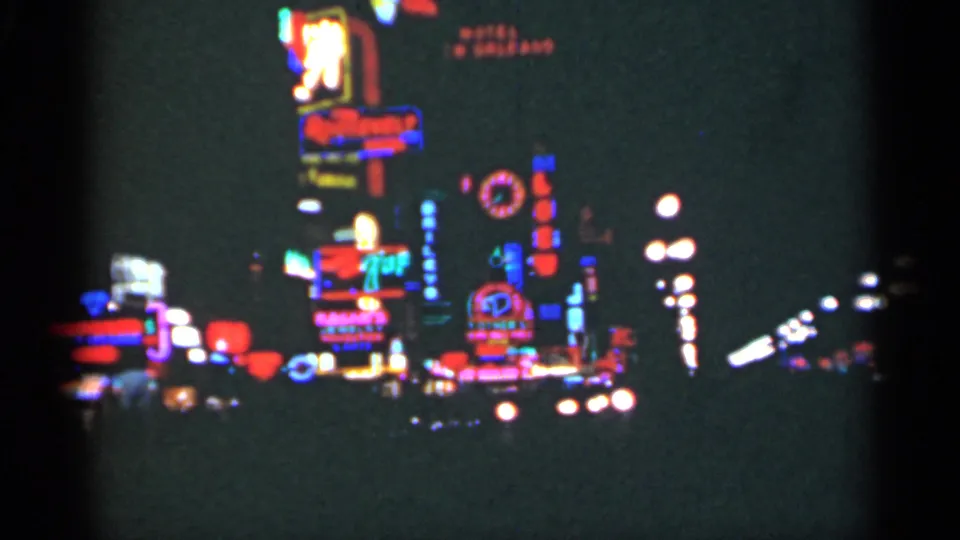1949 New Orleans street view with red, blue, and green neon signs glowing against a dark night background.