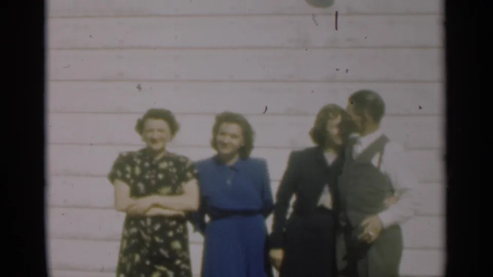 In this 1949 New Orleans home-movie frame, the group relaxes between poses as two women smile and the adults shift positions.
