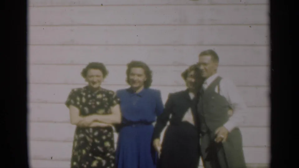 The final 1949 New Orleans frame shows four adults smiling and standing close together outside the clapboard house.