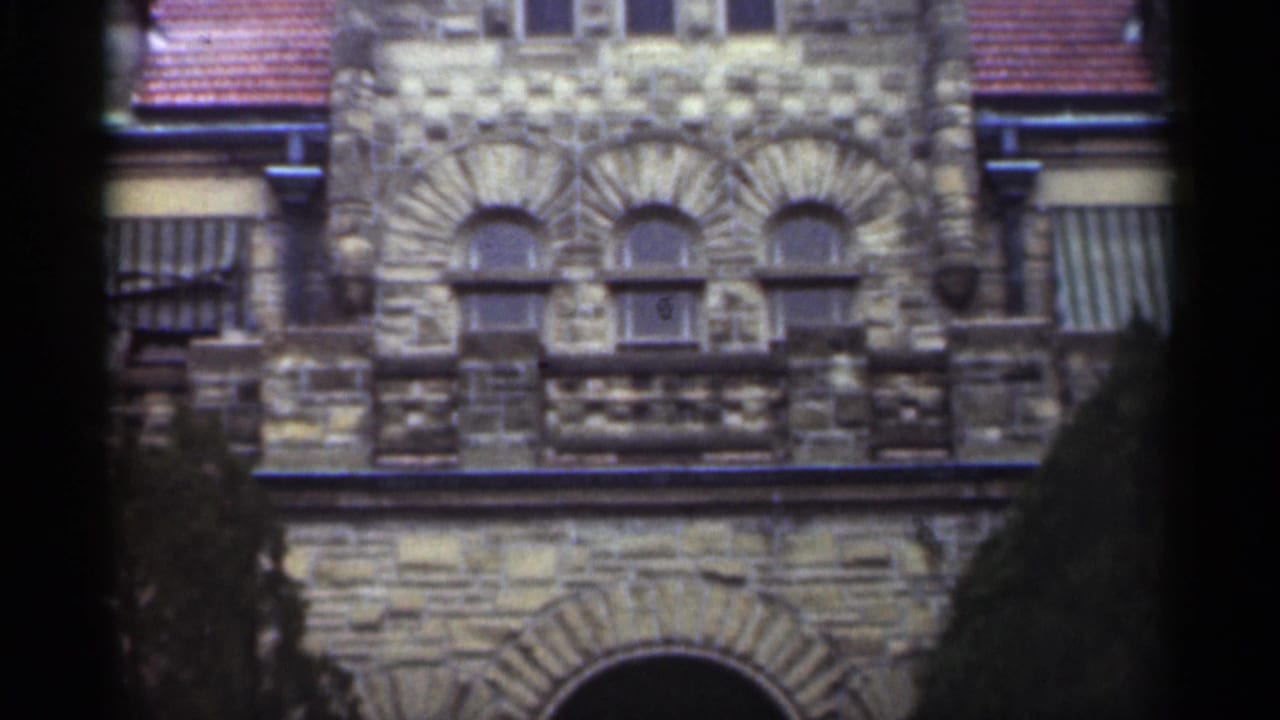 Grey stone church facade with arched windows and striped awnings.