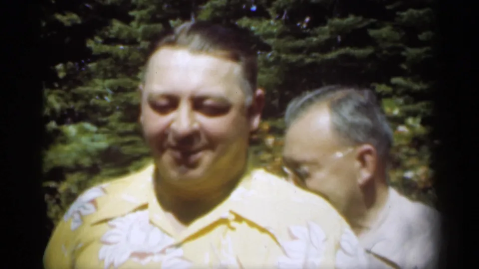 1949 New Orleans frame showing a close outdoor family-portrait moment, with one man facing the camera and another partly turned beside him.