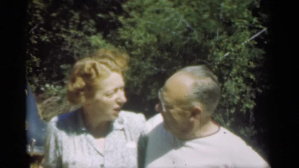 In the 1949 Santa Cruz clip, the older couple faces each other closely, with a blue car edge and leafy background visible.