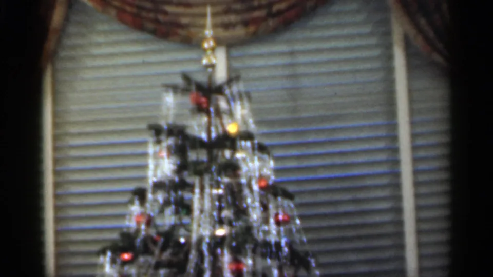 Christmas tree with lights, ornaments, venetian blinds, and drapery appears inside a Santa Cruz home in 1949.