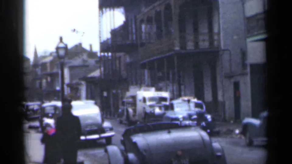 1949 Santa Cruz street view with parked automobiles, a pedestrian in dark clothing, balconies, and older building facades.