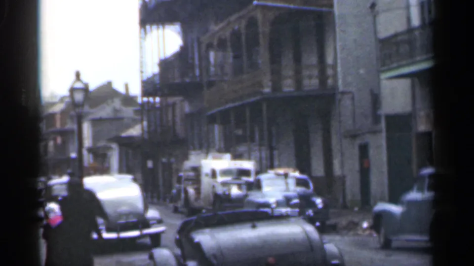 Santa Cruz street scene from 1949 showing a pedestrian, rows of mid-century cars, a streetlamp, and balcony-fronted buildings.