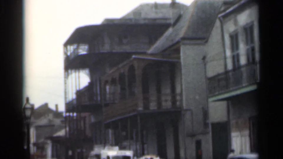 1949 Santa Cruz street scene with balcony-front buildings, a vintage street lamp, and cars entering the lower frame.