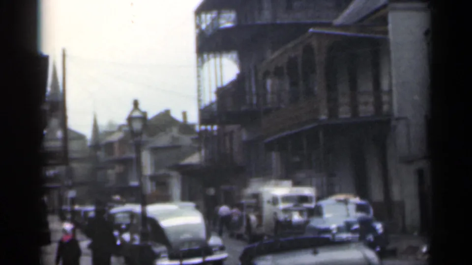 Santa Cruz, California, 1949 street view with pedestrians, parked cars, a delivery vehicle, balconies, and a distant steeple-like form.