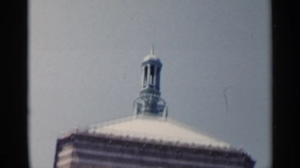 1954 New York 8mm frame showing a pale dome-like roof and small cupola above the ornate building exterior.