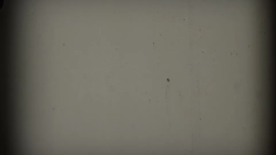 A transitional or blank portion of the 8mm scan shows muted exposure, dark frame edge, and minor dust specks.