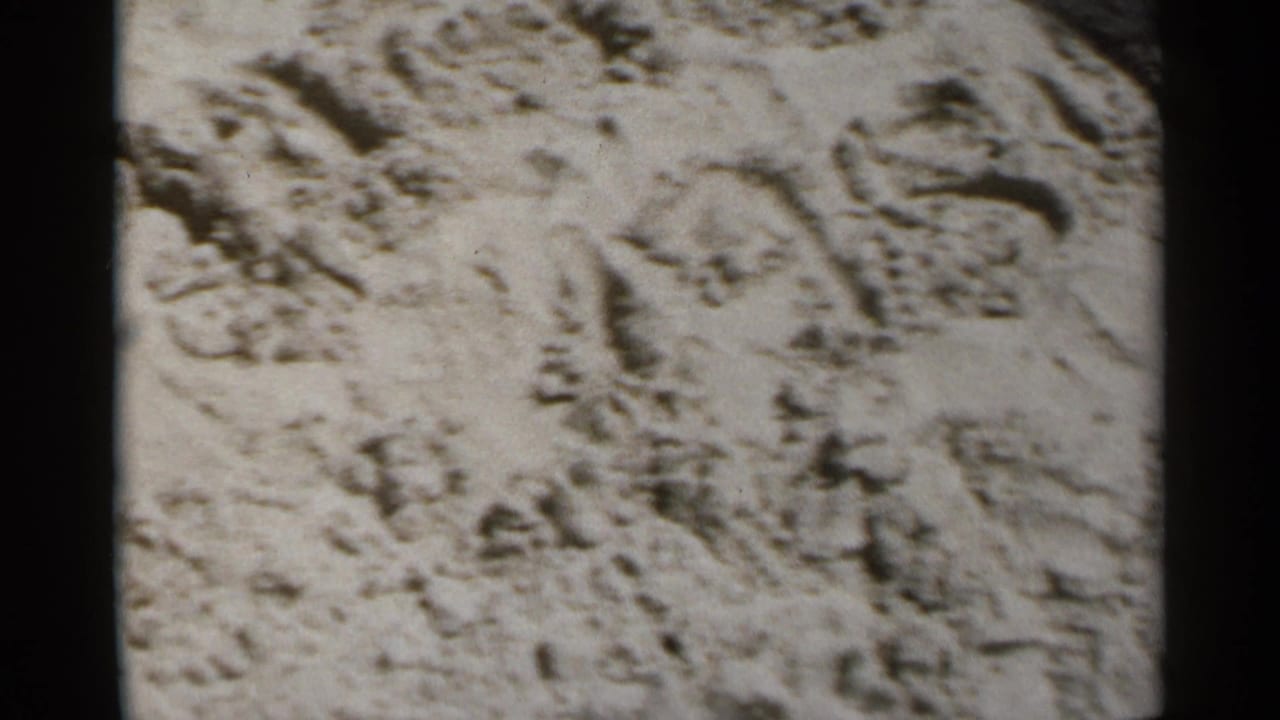 Close view of textured sand with footprints and uneven surface marks.