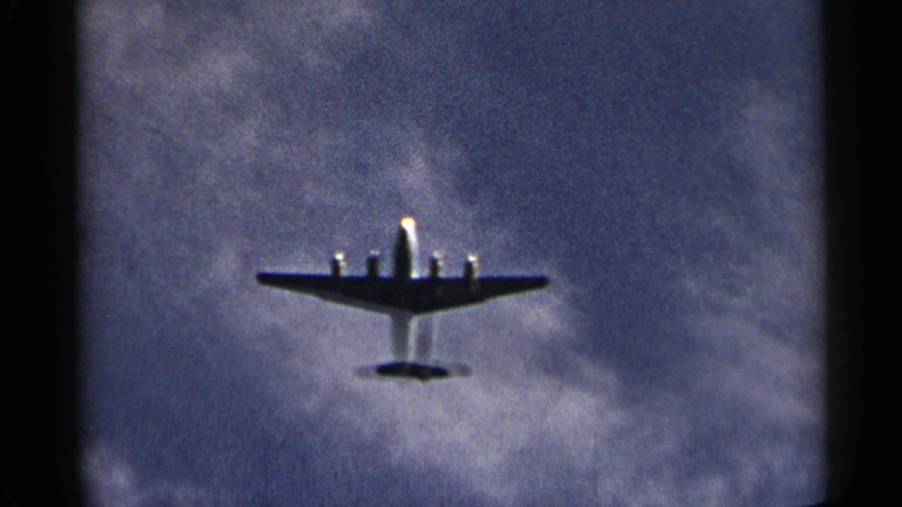Large propeller aircraft seen from below against a cloudy blue sky.