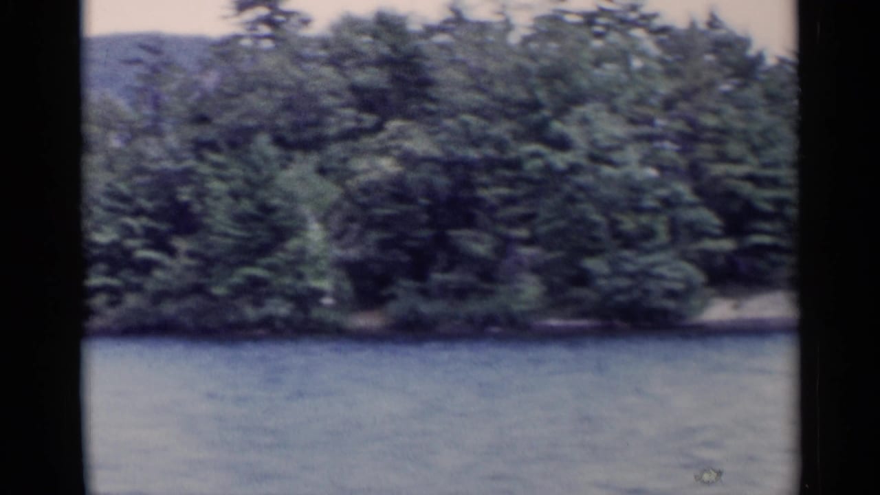 Lake water with wooded shoreline and distant mountain behind 8mm frame edges.