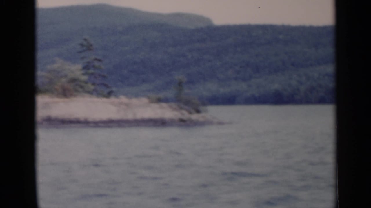 Small rocky shoreline or island with trees across the lake.