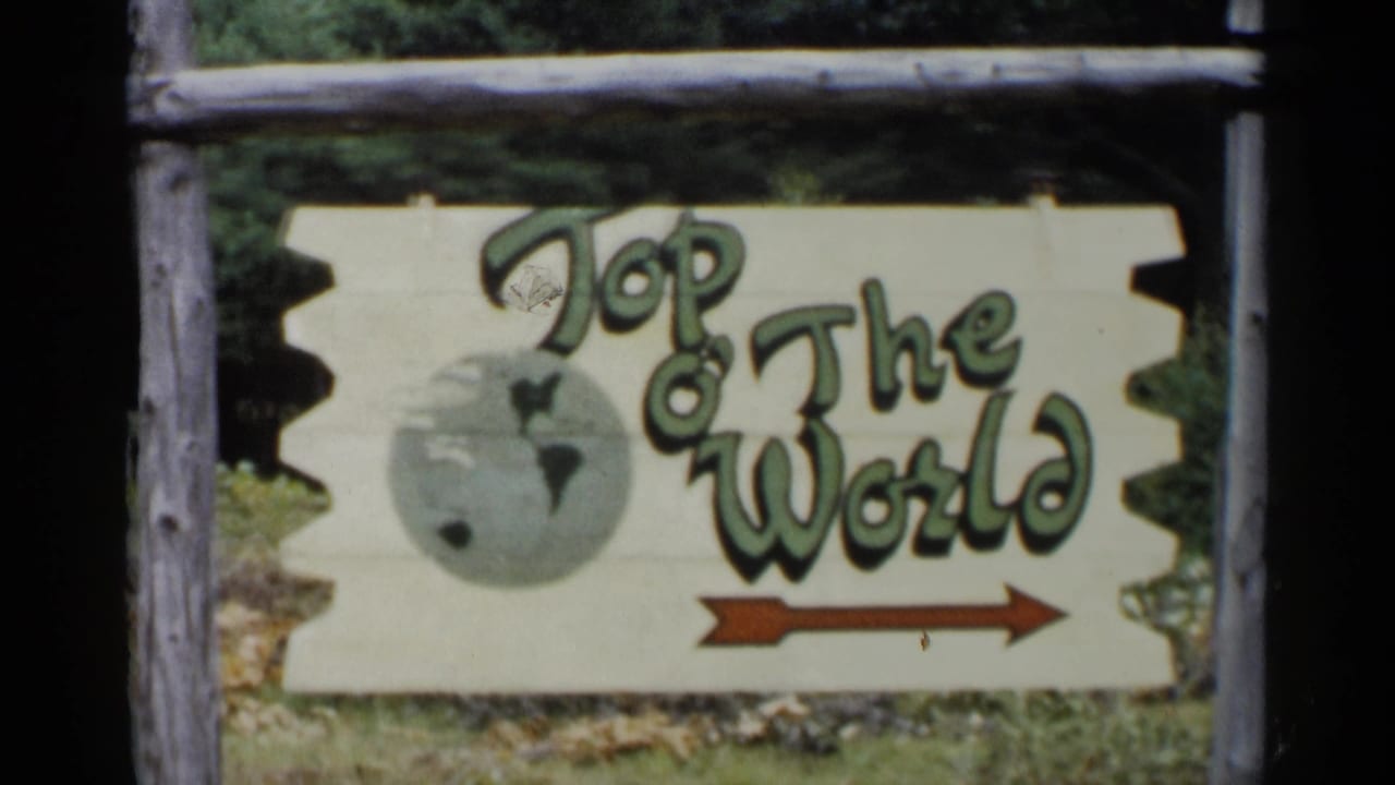 1955 Lake George 8mm frame showing a hand-painted Top O The World roadside sign in a rough log frame.