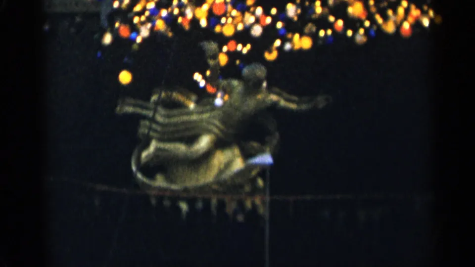 The clip ends on the golden sculptural form under colorful lights, filmed with soft focus and heavy 8mm grain.