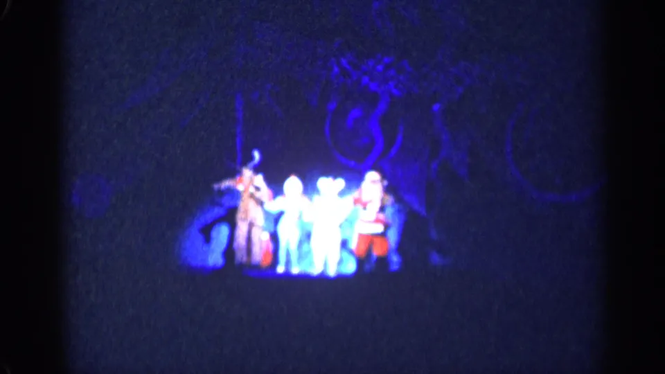 1955 New York City frame of a holiday stage group, including Santa-like and reindeer-like costumes, filmed from the audience.