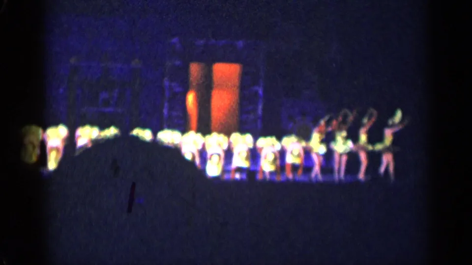 1955 New York City 8mm frame showing performers bowing or bending in a synchronized stage routine.