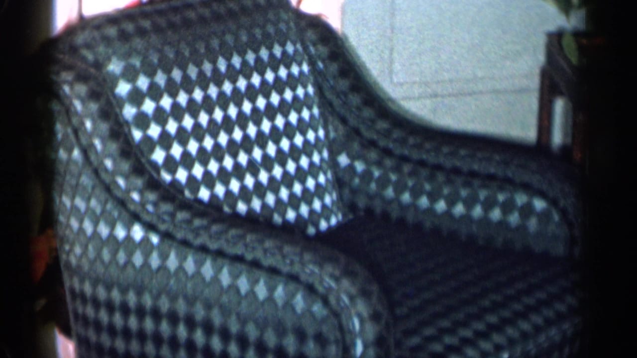 Blue diamond-pattern armchair seen close up inside a home.
