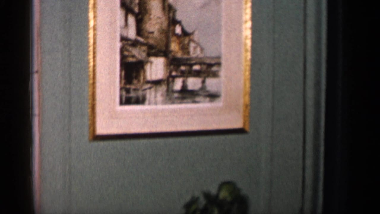 Framed castle artwork on a muted green wall above a dark lower edge.