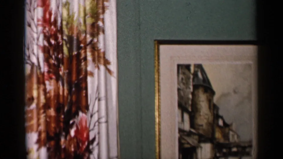 A floral-patterned curtain appears next to the framed castle picture in this New York City home interior from 1955.