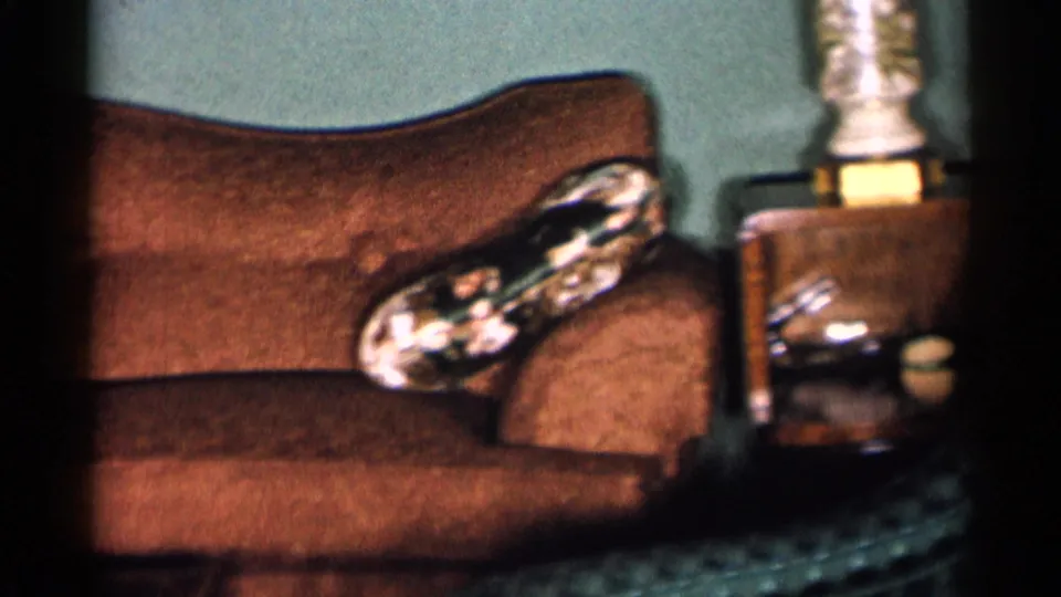 1955 New York City living room view showing the sofa, patterned ashtray, wooden side table, lamp base and small tabletop objects.