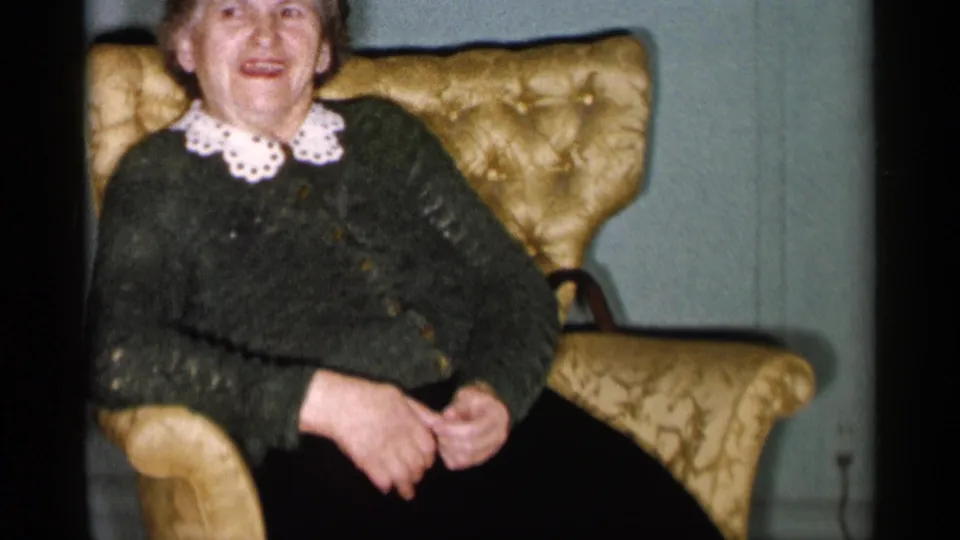 The same woman appears seated in a gold upholstered chair, smiling in a softly lit 1955 New York City interior.