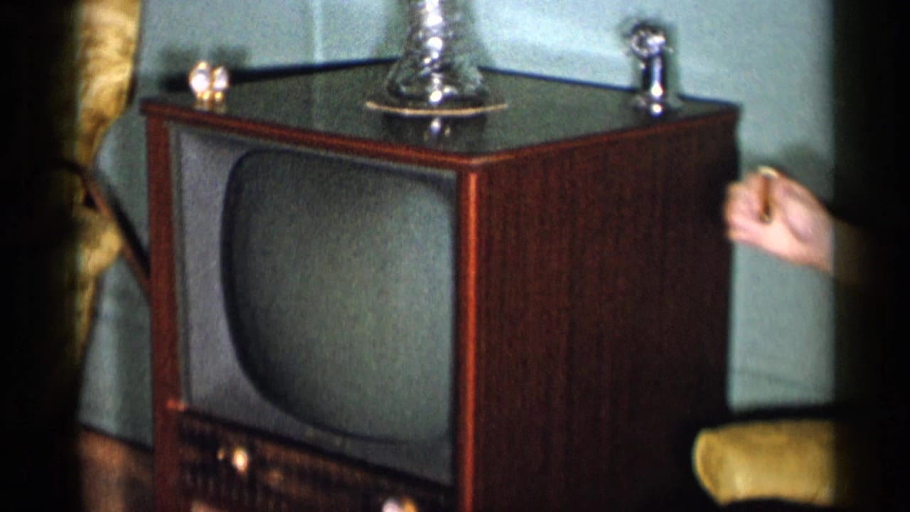 Wooden console television beside a seated woman in a private living room.