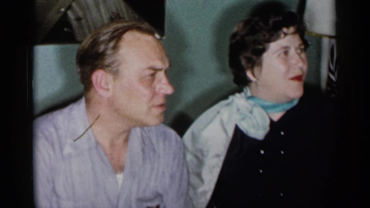 Man and woman seated together on a couch, both turned toward the right.