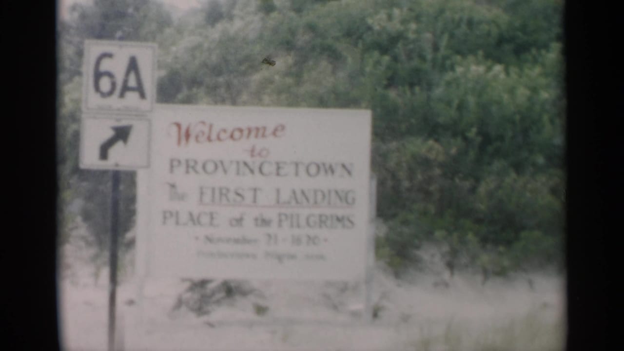 Soft 8mm frame of the Provincetown first landing place sign next to a Route 6A marker against roadside greenery.