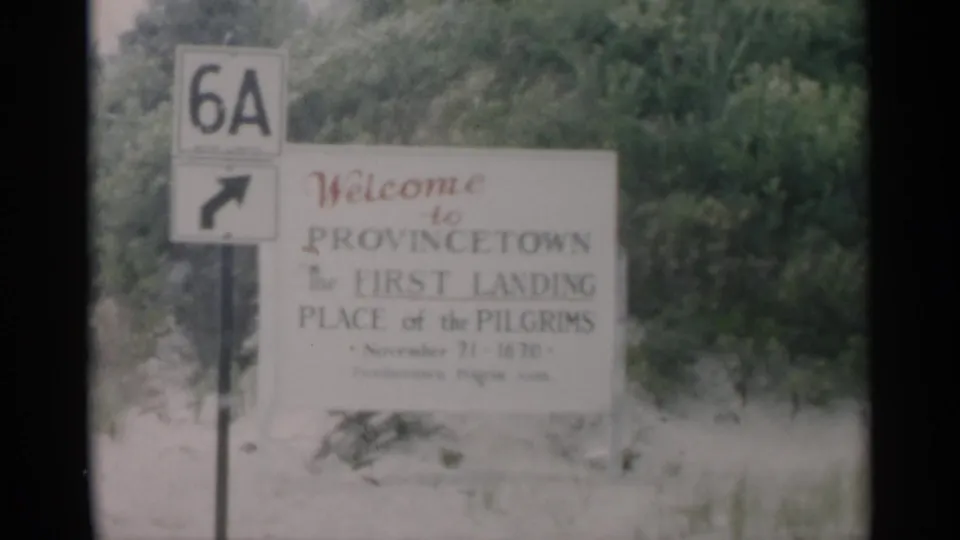 1956 Cape Cod roadside view with a Provincetown welcome sign, Route 6A marker, and trees in soft 8mm color.