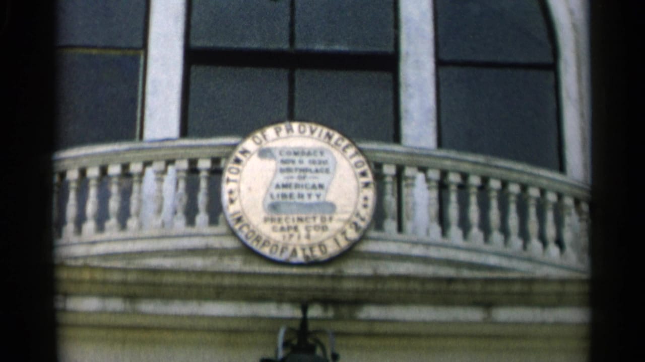 Town of Provincetown seal above a white balcony and arched windows.