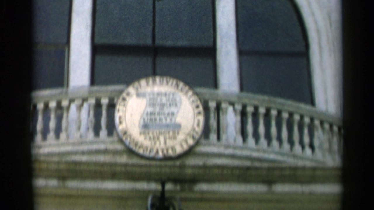 Close 8mm view of the Provincetown town seal centered on a white balcony facade in Cape Cod, Massachusetts.
