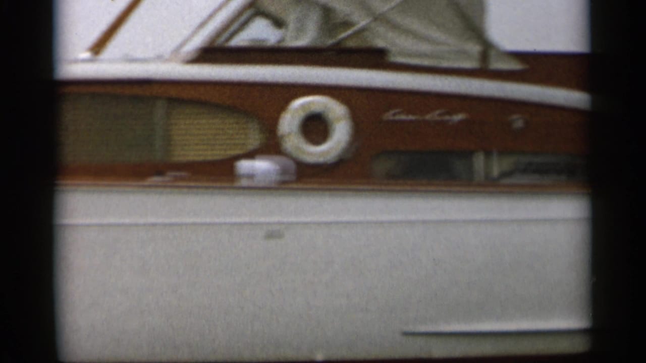 Close view of the motorboat side with cabin windows and a life ring.