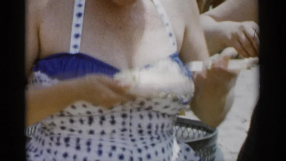 A woman at Jones Beach in 1956 holds a plate and food while participating in a casual beach eating contest.